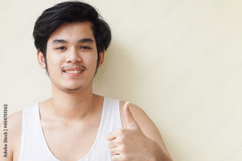 Asian wearing a gray sweater handsome young man smiling indoors with yellow background concept. Asian wearing a gray sweater handsome young man smiling indoors with yellow background concept.