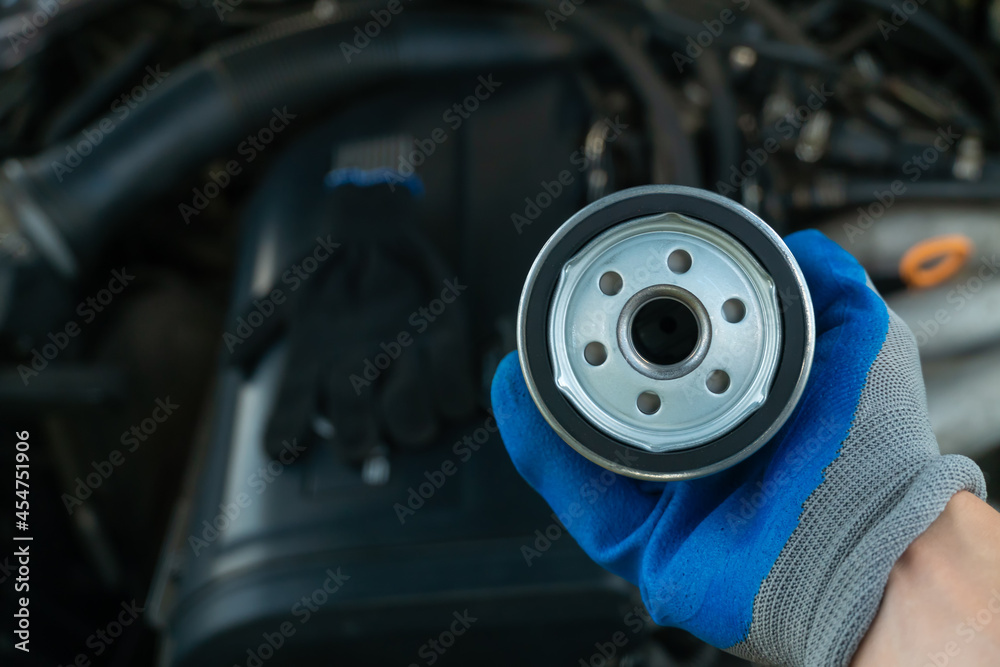 Replacing the oil filter. Car engine maintenance mechanic holds an oil