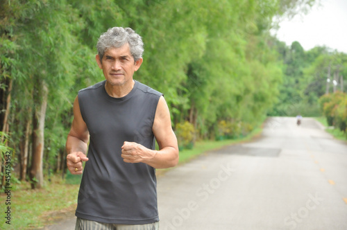 an old man running along the road among the nature atmosphere, when coronavirus or Covid-19 is spreading to stay away from people to be safe from Covid-19 infection