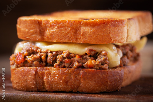 Fotografía sloppy joe sandwich with ground meat and cheese on a wooden board