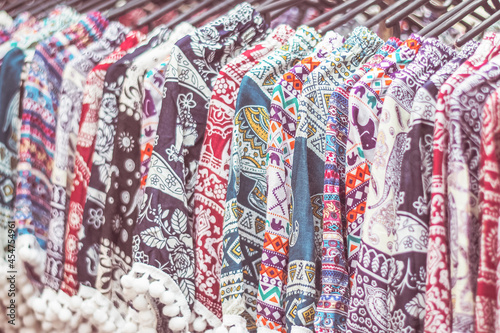 clothes hanging on a rack in a flea market Souvenir shop in Thailand  © Parichart