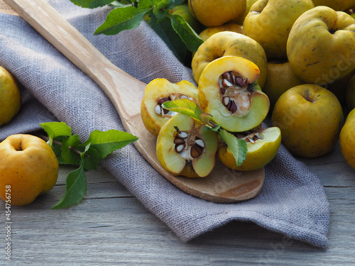 Konstfotografi Ripe yellow fruit of the shrub Chaenomeles japonica with a wooden spoon on a wooden background, top view