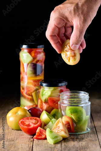 Hand preparing some canned tomatoes