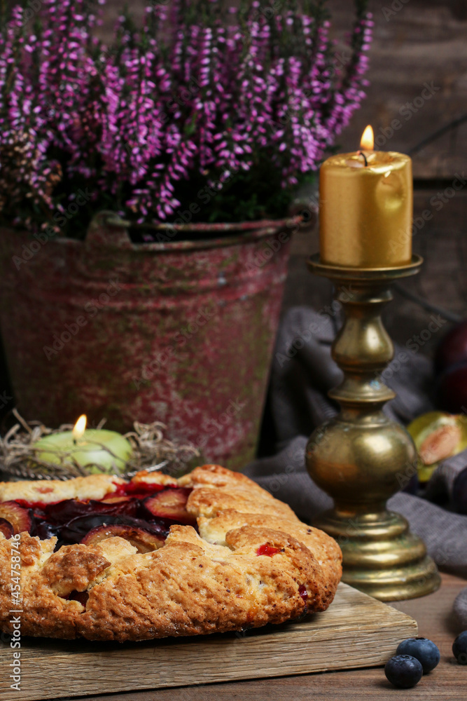 Traditional round plum pie on the table.