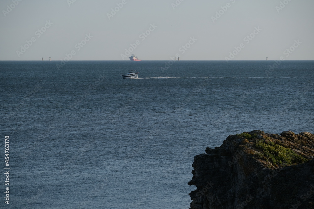 A view of a construction site offshore. An offshore wind turbines installation in the west of France not far from Saint-Nazaire. August 2021, France. A view of a construction site offshore. An offshore wind turbines installation in the west of France not far from Saint-Nazaire. August 2021, France.
