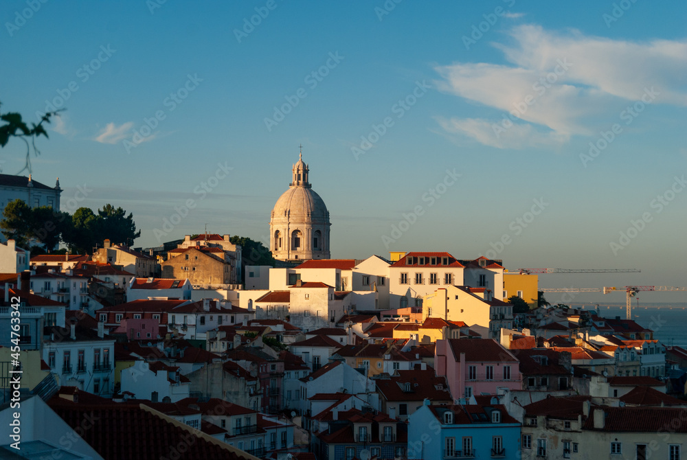 A panorama of Lisbon city at sunset buildings in the shadow golden hour last rays of sun on the National Pantheon - Lisbon, Portugal