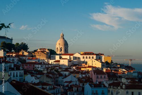 A panorama of Lisbon city at sunset buildings in the shadow golden hour last rays of sun on the National Pantheon - Lisbon, Portugal