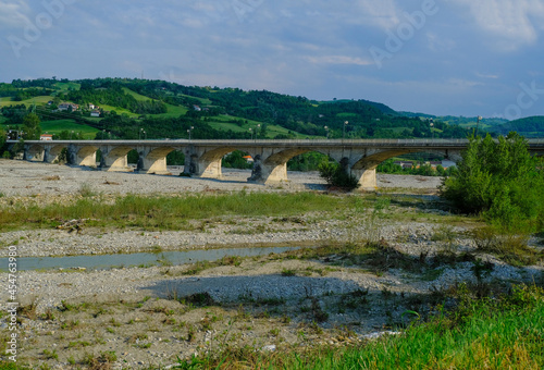 bridge over the mountains river Torrente Parma in summer across green hills. Langhirano, Emilia-Romagna, Italy