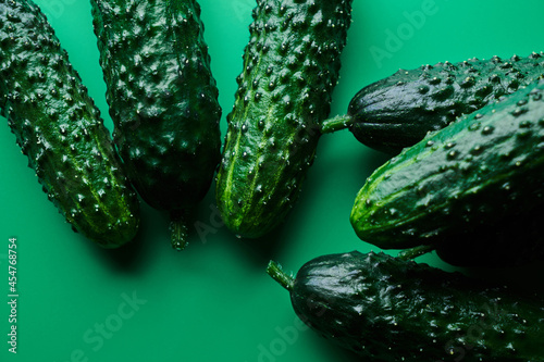Set of fresh whole cucumbers on a green background  food pattern. Garden cucumber wallpaper backdrop design