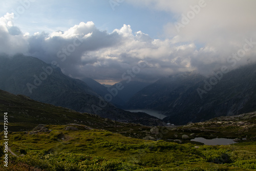 Amazing Landscape in the hearth of Canton Bernese in Switzerland. Drive on the Grimselpass. Epic scenery with the clouds and fog. Wonderful sun rays through the clouds and later an amazing sunset.