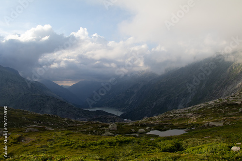 Amazing Landscape in the hearth of Canton Bernese in Switzerland. Drive on the Grimselpass. Epic scenery with the clouds and fog. Wonderful sun rays through the clouds and later an amazing sunset.