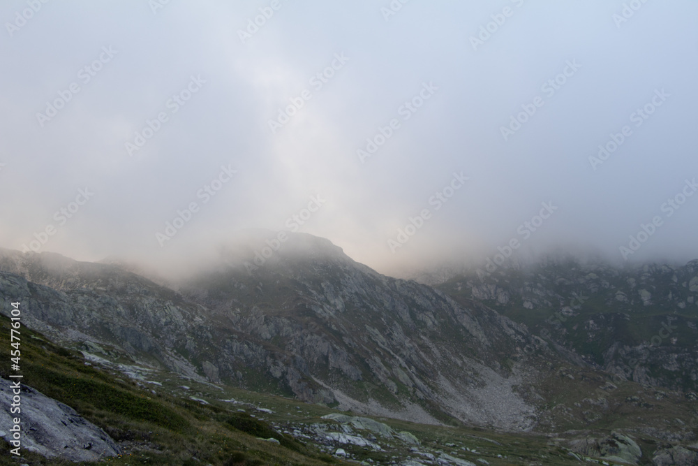 Amazing Landscape in the hearth of Canton Bernese in Switzerland. Drive on the Grimselpass. Epic scenery with the clouds and fog. Wonderful sun rays through the clouds and later an amazing sunset. Amazing Landscape in the hearth of Canton Bernese in Switzerland. Drive on the Grimselpass. Epic scenery with the clouds and fog. Wonderful sun rays through the clouds and later an amazing sunset.