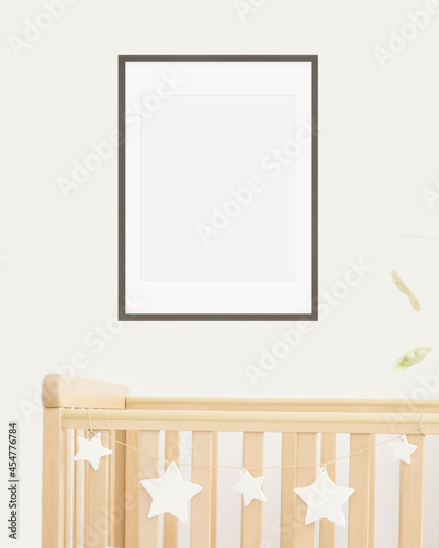 Mock up poster frame in children room, nursery room with wooden crib for kids with white ceramic stars, close-up, white wall, scandinavian style