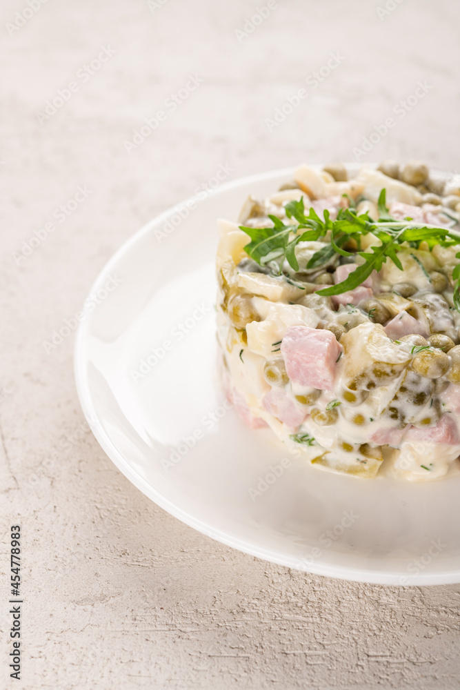 Olivier salad with chicken on a white plate Olivier salad with chicken on a white plate