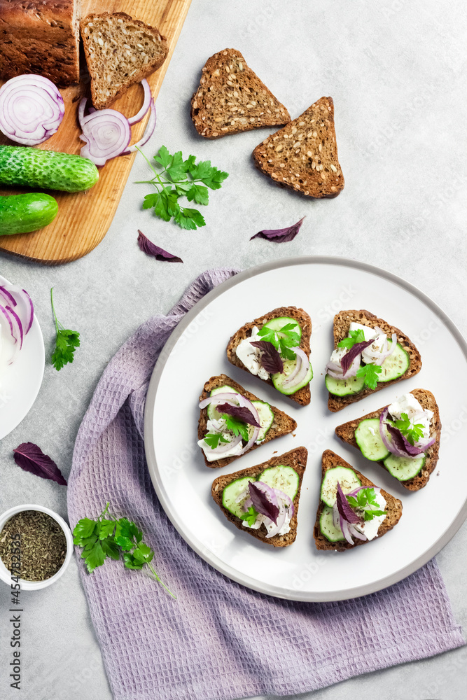 Canapes with toasted bread with sunflower and flax seeds, feta cheese, cucumber and onion Canapes with toasted bread with sunflower and flax seeds, feta cheese, cucumber and onion