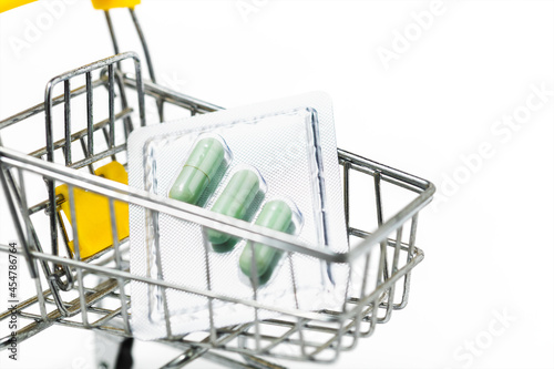 Green chiretta herbal capsule in the shopping cart against white background for healthcare and medical concept photo