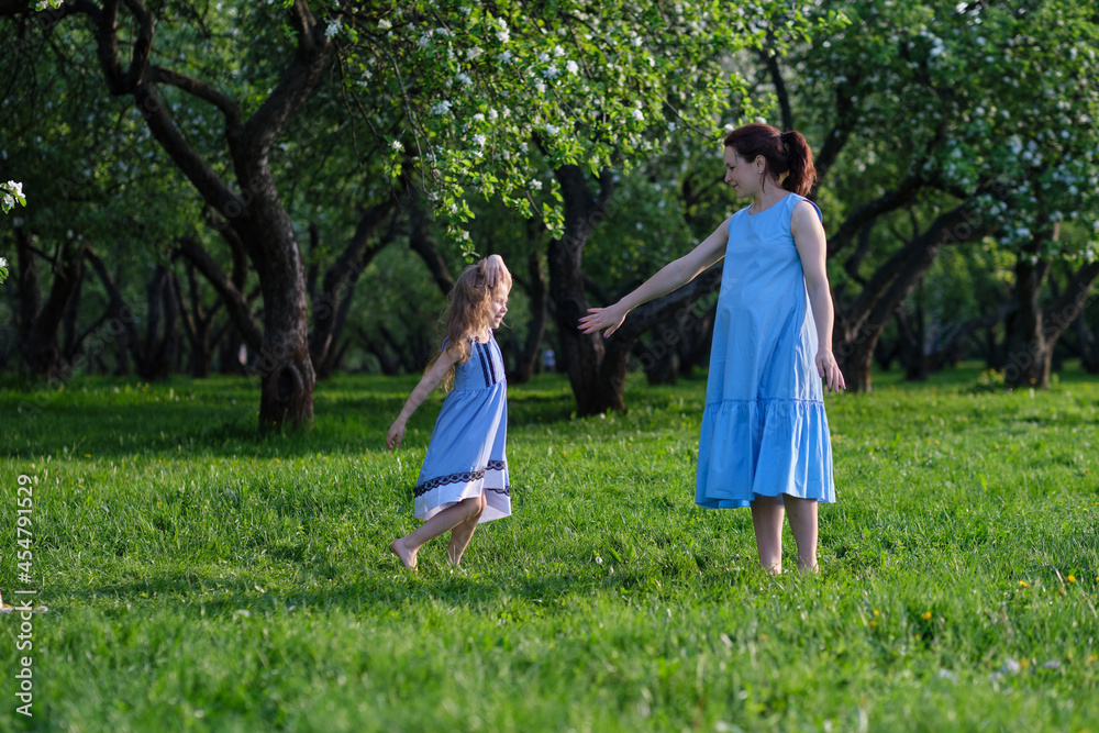Fototapeta premium nature scene with family outdoor lifestyle. Mother and little daughter playing together in a park. Happy family concept. Happiness and harmony in family life.