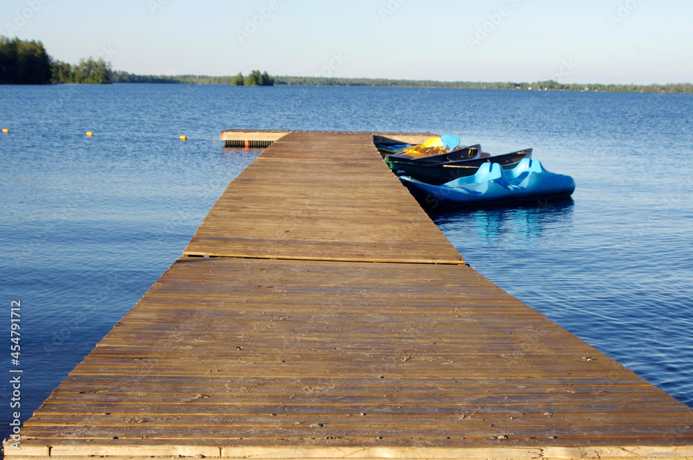 wooden dock on blue water with blue sky and copy space