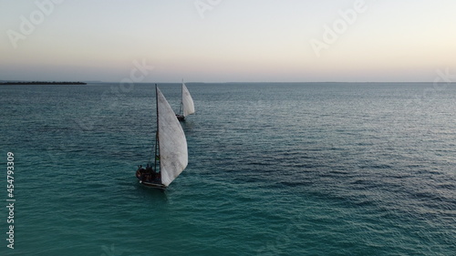 Two traditional African sailboats observing sunset in Nengwa, Zanzibar photo