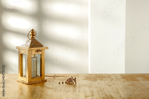 Golden festive Christmas table and shadow on the wall 