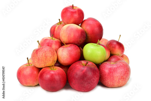 A pile of red and yellow apples. Among them is one green apple. Isolated on white background