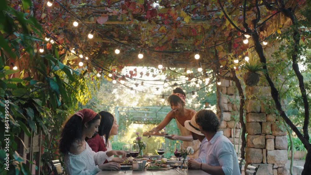 friends making toast celebrating dinner party drinking wine eating mediterranean food sitting at table enjoying beautiful summer day outdoors 4k footage 