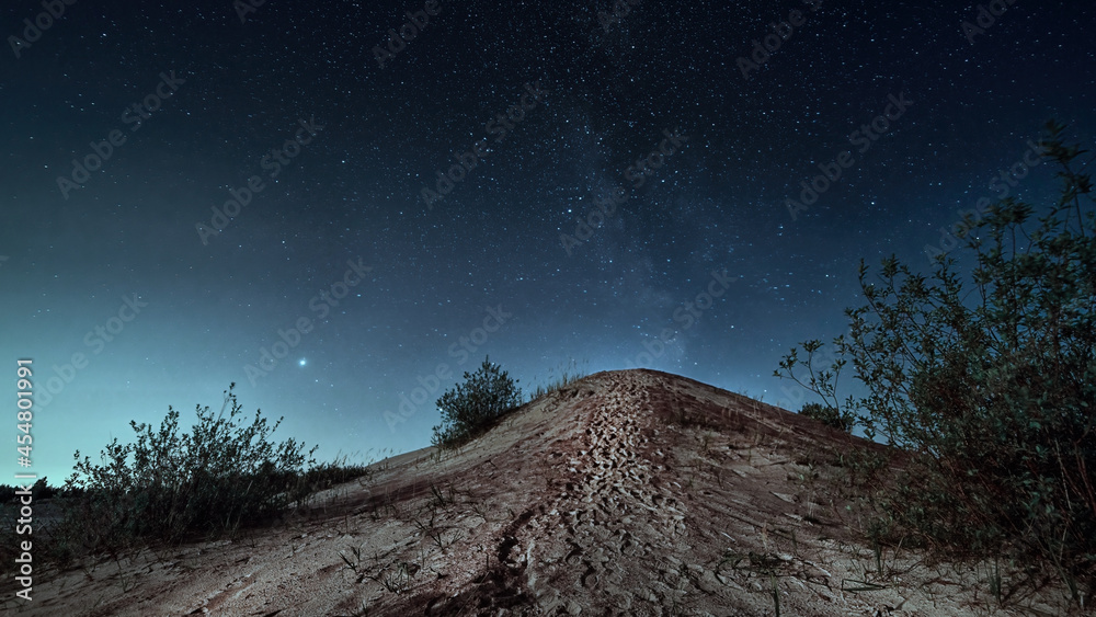 Night scene with sand hill in moon light and starry sky.