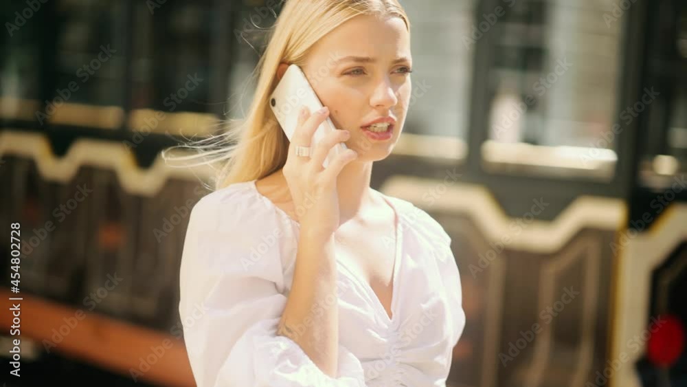 Portrait of beautiful blond young woman having phone talk outdoor. Slow motion of attractive girl with smartphone. High quality 4k footage Portrait of beautiful blond young woman having phone talk outdoor. Slow motion of attractive girl with smartphone. High quality 4k footage