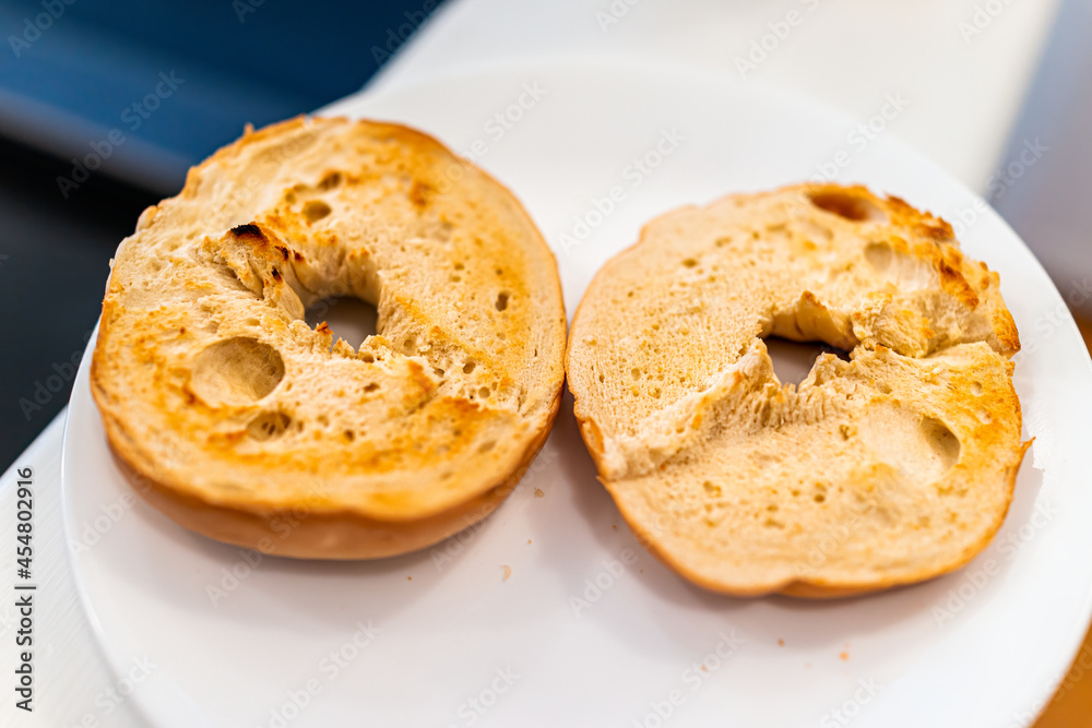Bagel bread toasted slices closeup on white plate as breakfast food with plain no toppings