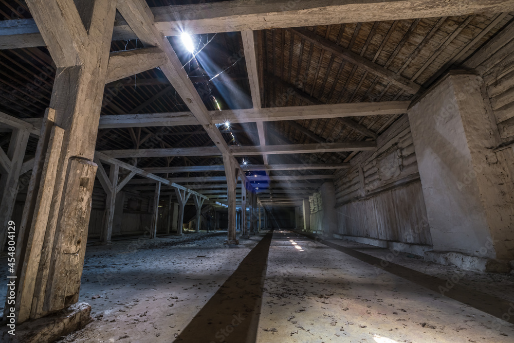 Fototapeta premium inside dark abandoned ruined wooden decaying hangar with rotting columns