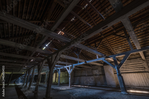 inside dark abandoned ruined wooden decaying hangar with rotting columns © hiv360