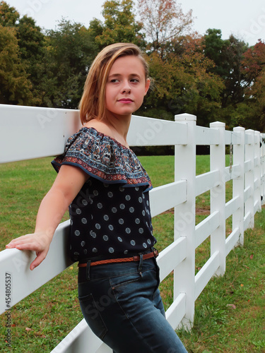 Teen girl leaning against fence