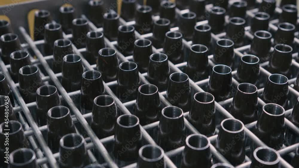 Motion over rack with workpieces for gun bullets in light production plant workshop focus becomes clear extreme close view Motion over rack with workpieces for gun bullets in light production plant workshop focus becomes clear extreme close view