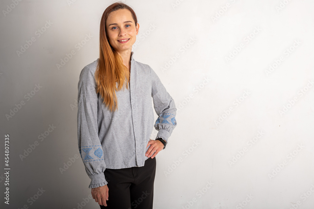 Portrait of a happy, pretty and positive girl, a woman with long blond hair, smiling carefree, standing in a gray brace on a light background. Portrait of a happy, pretty and positive girl, a woman with long blond hair, smiling carefree, standing in a gray brace on a light background.