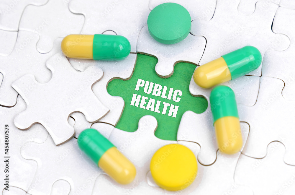 There are pills and vitamins on the white puzzles. Inside on a green background the inscription - PUBLIC HEALTH There are pills and vitamins on the white puzzles. Inside on a green background the inscription - PUBLIC HEALTH
