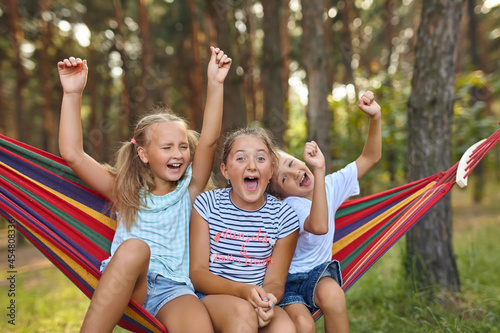 Fun in the garden kids playing in colorful hammock photo