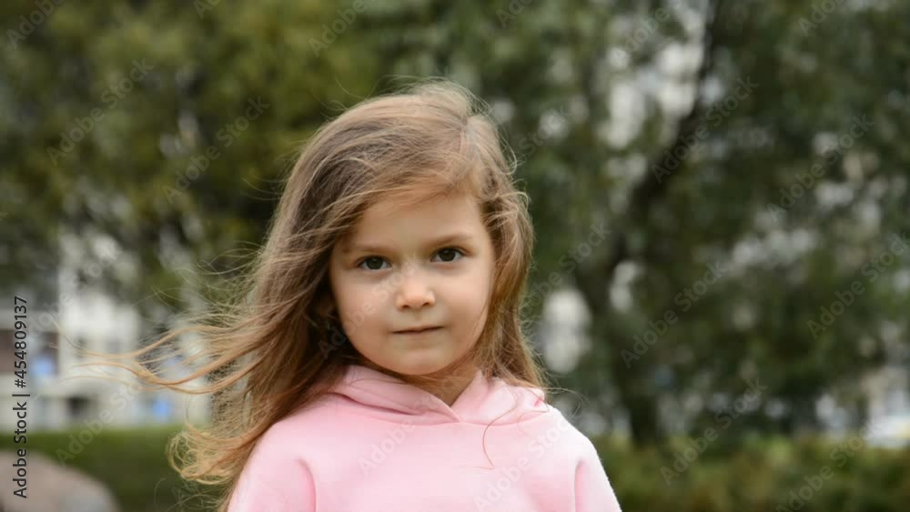Little beautiful girl portrait close on the background of trees in the city park Little beautiful girl portrait close on the background of trees in the city park