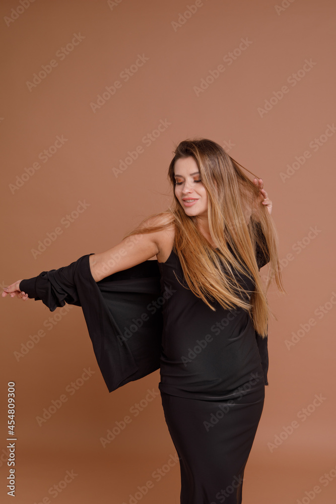 Beautiful pregnant young woman in studio on beige background Beautiful pregnant young woman in studio on beige background