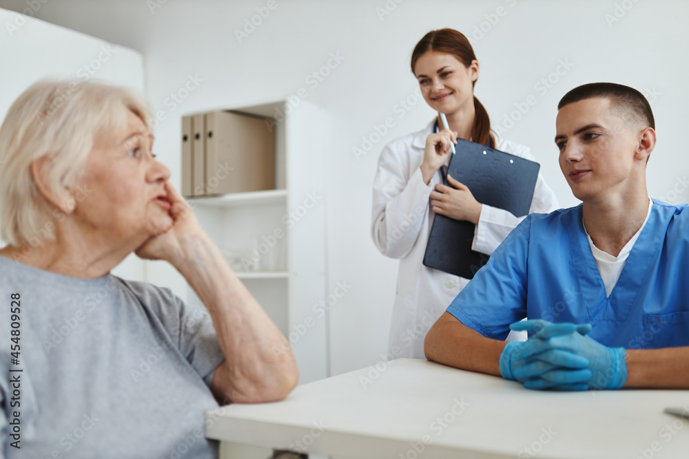 Obraz premium elderly woman patient in hospital talking to medical staff