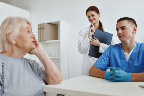 elderly woman patient in hospital talking to medical staff