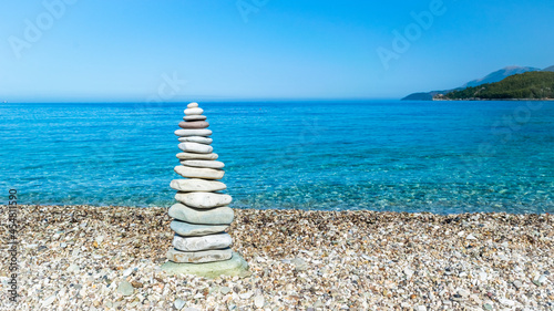 Foto Sea pebble turret for good luck on beach.