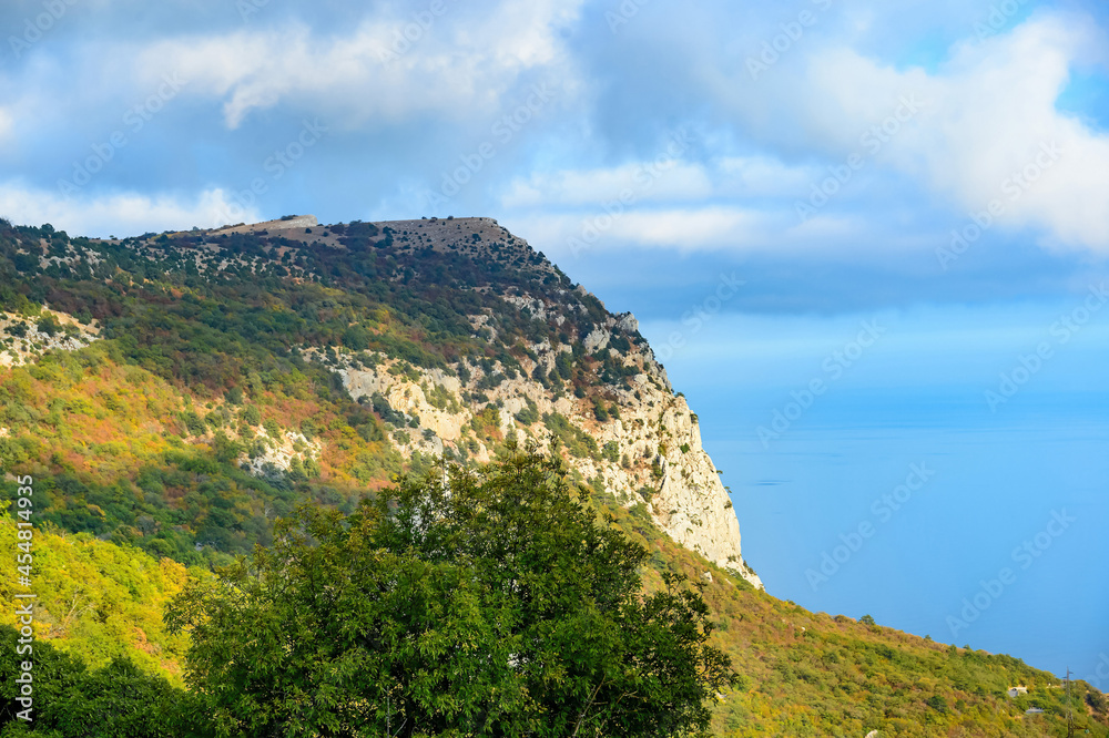 Steep cliffs of the Crimea. Ocean under the rocks. Mountains by the sea, travel.