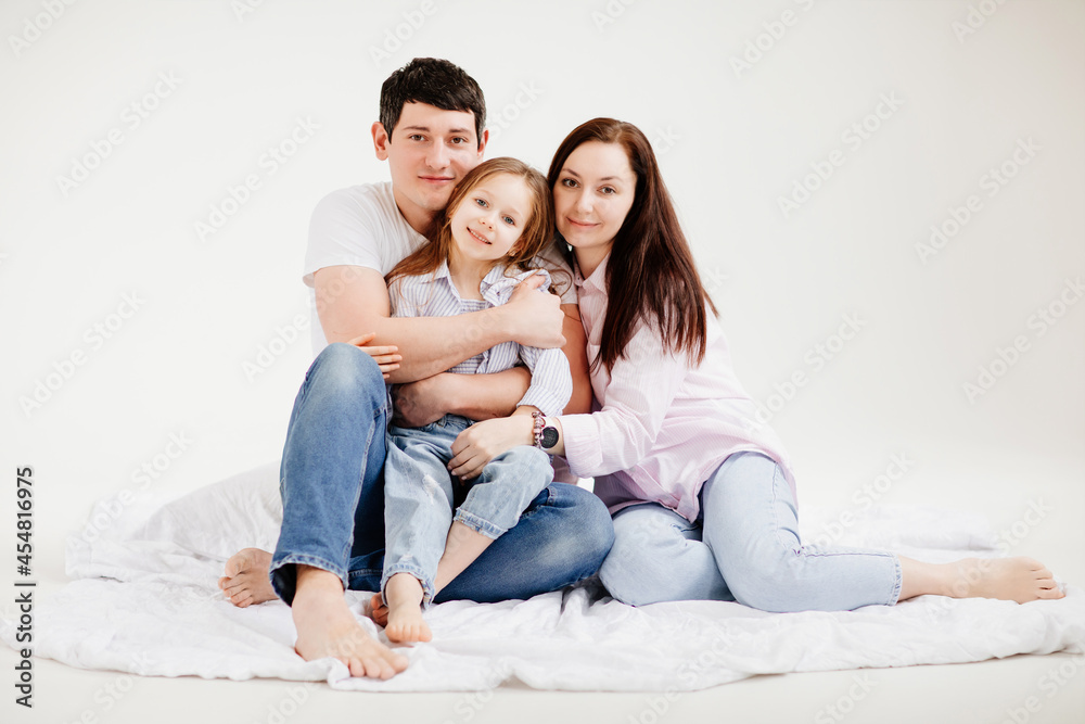 beautiful happy family cuddling in a white photo studio. backstage. beautiful happy family cuddling in a white photo studio. backstage.
