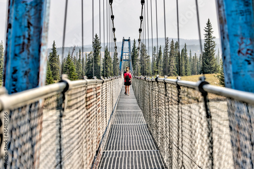 Mother and son hiking along a bridge crossing the South Saskatchewan River in the Nordegg Region of the Canadian Rocky Mountains photo