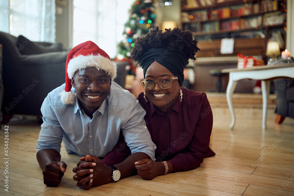 Fototapeta premium Young happy African American couple at home on Christmas day.