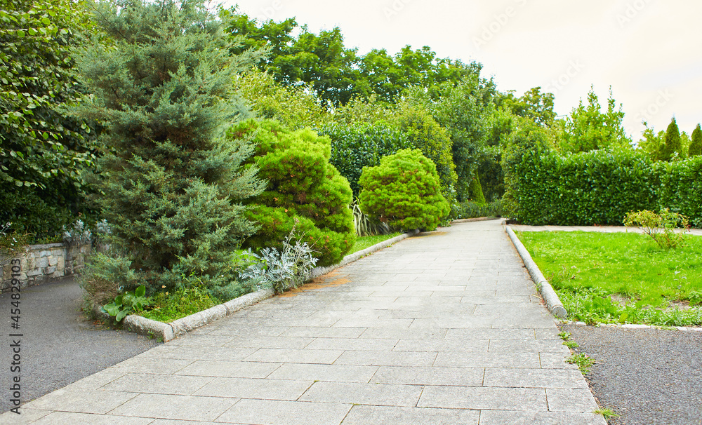 Decorated garden with path in the summer park.