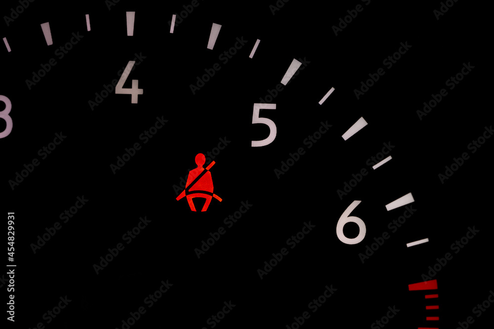 Seat belt warning light on vehicle dashboard. Safety restraint law