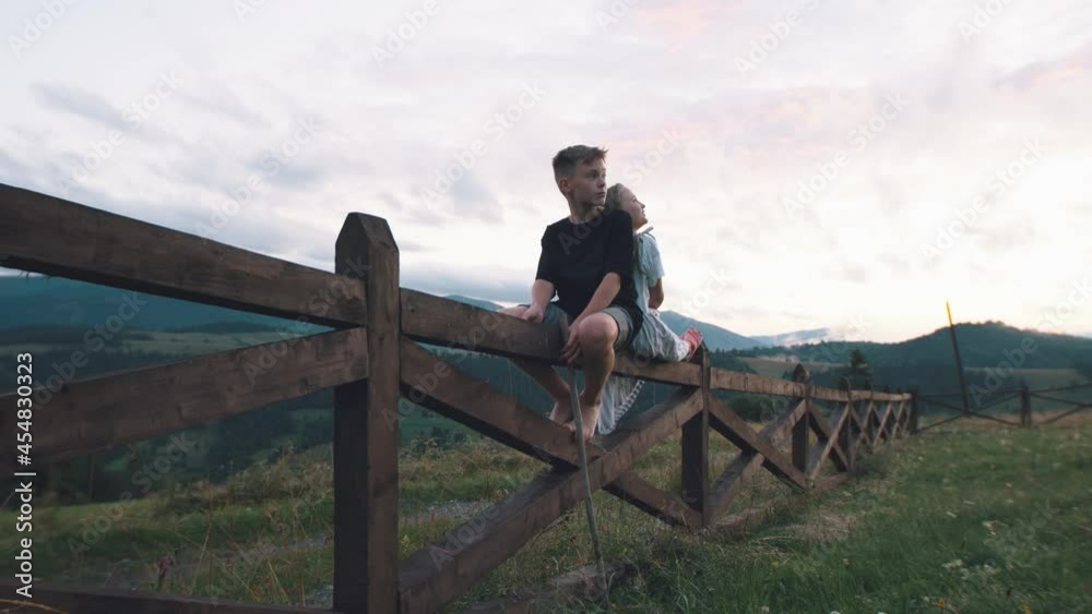 Children on fence admiring mountains Children on fence admiring mountains