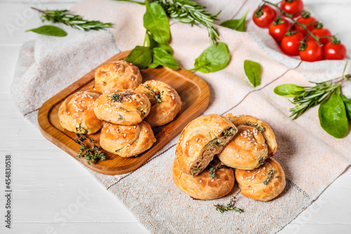 Puff pastry stuffed with spinach on white wooden background