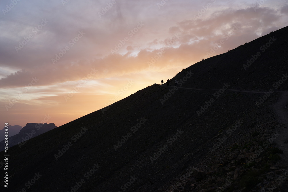 sunset over the mountains with people seeking for